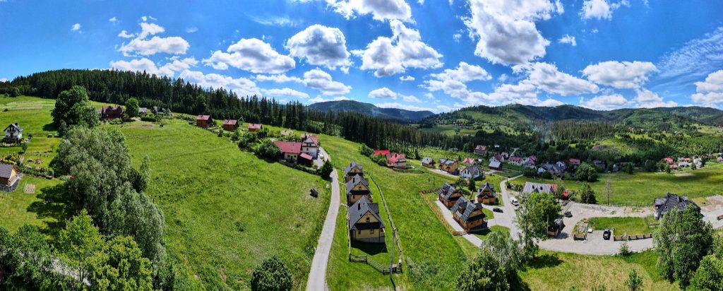 Drewniane domy w górach w Beskidach – panorama górskiej doliny i domków wakacyjnych